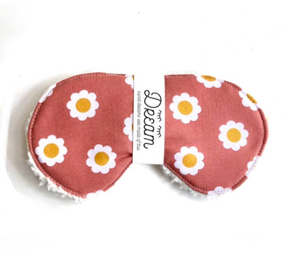 Front view of terra cotta daisy cotton sleep mask with soft Sherpa back, labeled 'Dream'. Lightweight and breathable for nighttime comfort.