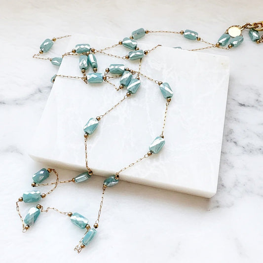 Necklace with blue beads on a white marble surface