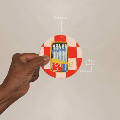 Hand holding Sardines Seedlings Coaster showing foil details and cork backing, highlighting durability and stylish design for home use.