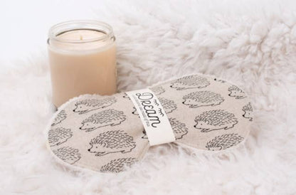Sweet Dreams Sleep Mask - Linen Hedge Hog pattern shown beside a candle on a fluffy surface, ideal for home relaxation and restful sleep.