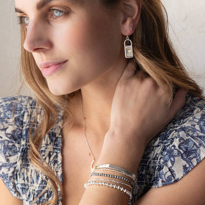 Miyuki Frame Earrings - Ivory/Silver worn by model with coordinating silver jewelry, emphasizing hypoallergenic and modern appeal.