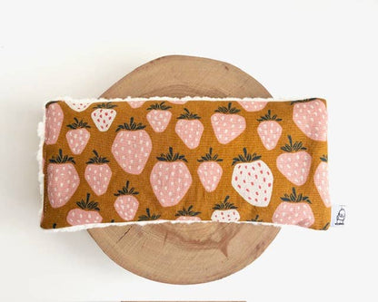 Strawberry print eye pillow on wooden surface