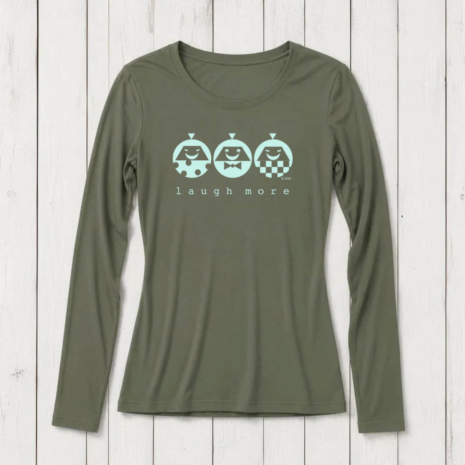 Olive green long sleeve T-shirt with playful graphic of three smiling characters and the phrase 'laugh more' printed below, made from soft cotton blend, casual wear for women.