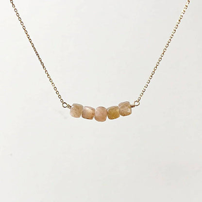 Minimalist gold necklace with five faceted peach moonstone beads on a dainty chain from the Gemstone Gold Earrings Necklace Set.