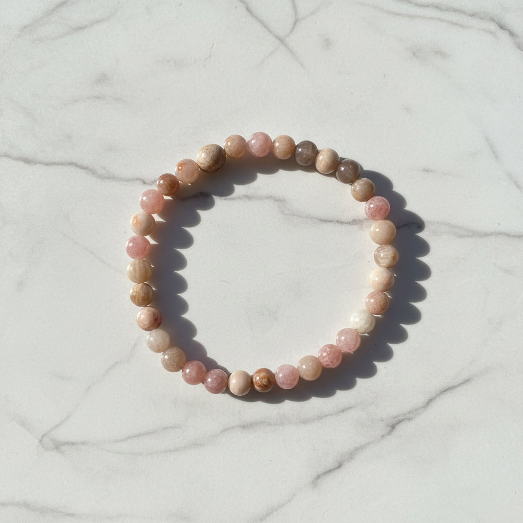 Pink and beige gemstone bracelet on marble background