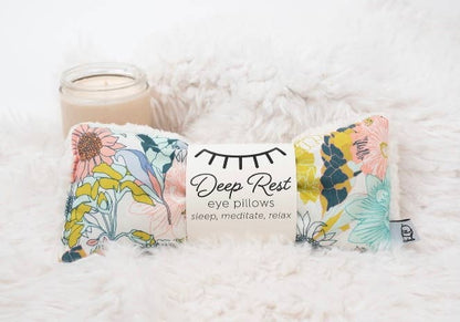 Weighted Eye Pillow in Meadow design on soft faux fur, shown with candle for calming self-care and deep rest ambiance.