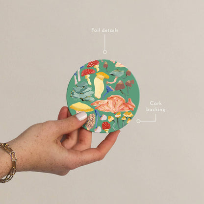 Plantable Shrooms Seedlings Coaster with colorful mushroom illustrations, foil details, and cork backing for heat and water resistance.