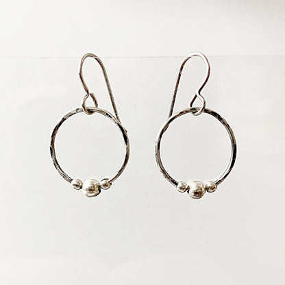 Circle Fidget Earrings from the Circle Fidget Jewelry Set, with hammered silver hoops and three bead accents, shown against a white background.