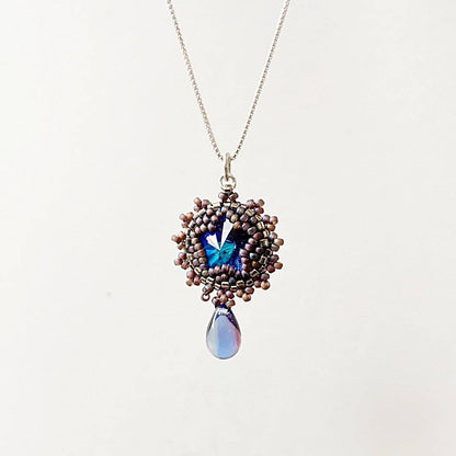 Elegant beaded crystal necklace with a round blue Austrian crystal pendant and teardrop charm, ideal for special occasions.