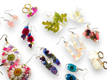 Assorted resin earrings with real flowers in various shapes and colors. Handmade pressed flower earrings with gold and silver hooks.