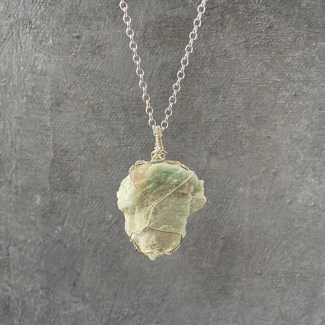 Wire Wrapped Amazonite Necklace with raw blue-green gemstone on sterling silver chain, handcrafted for natural elegance and calming energy.