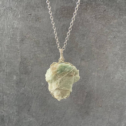 Wire Wrapped Amazonite Necklace with raw blue-green gemstone on sterling silver chain, handcrafted for natural elegance and calming energy.