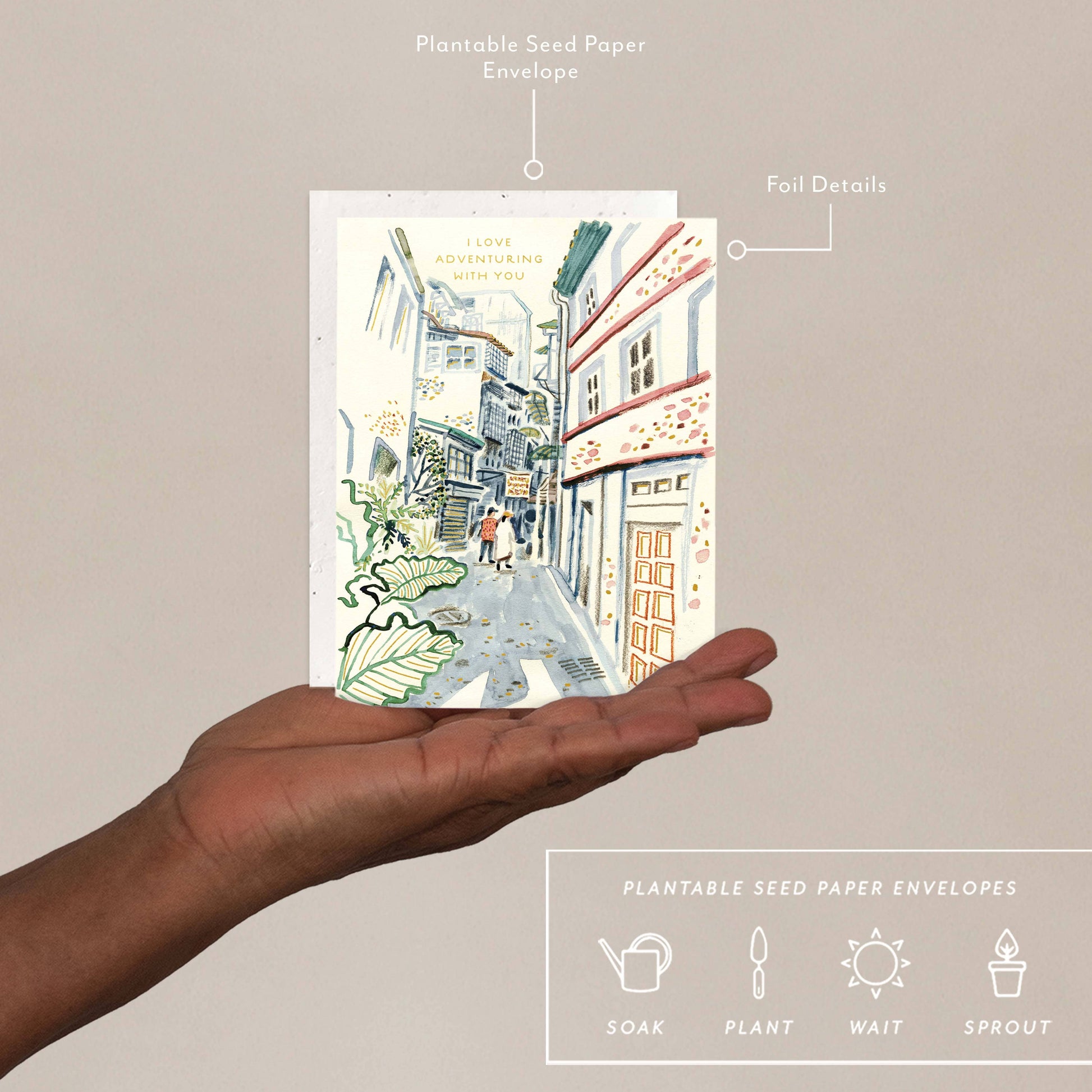 Eco-Friendly Love + Friendship Card - Plantable Envelopes shown on hand with labeled features like foil details and biodegradable seed paper.