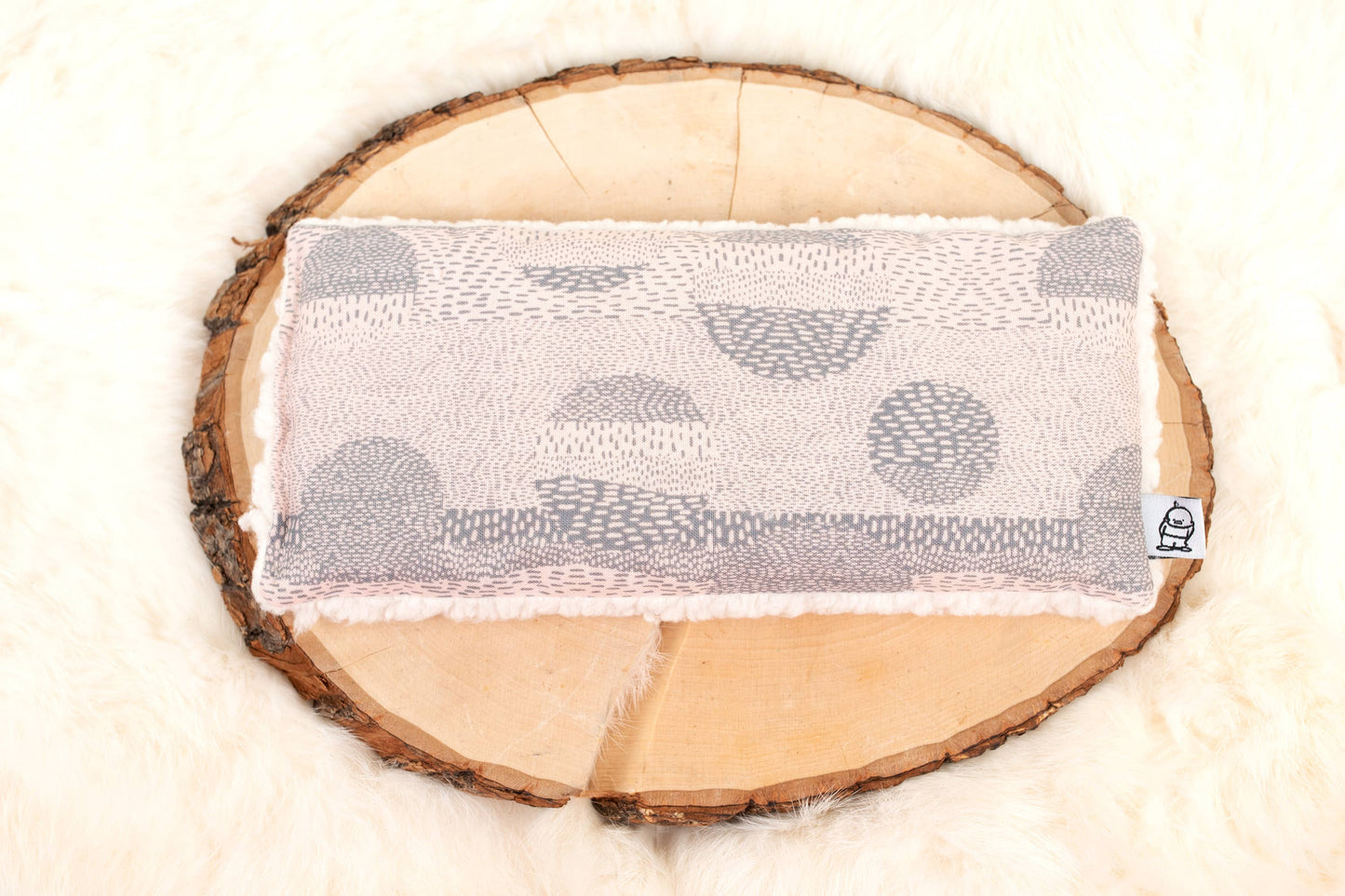 Weighted Eye Pillow for Relaxation | Stress Relief Aid displayed on a wooden slice with soft fleece backing and soothing abstract design.