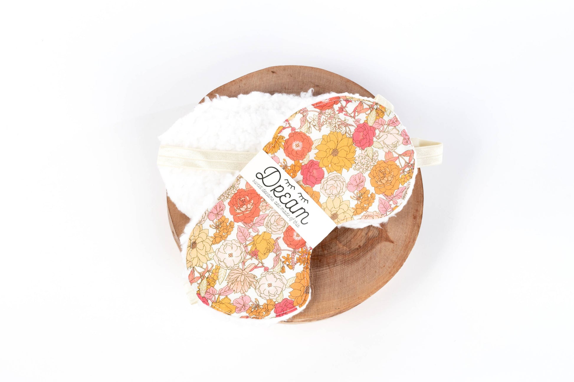 Liberty Sweet Dreams cotton sleep mask with floral print and soft cream minky backing, displayed on a wooden tray. Ideal for relaxation and sleep aid.