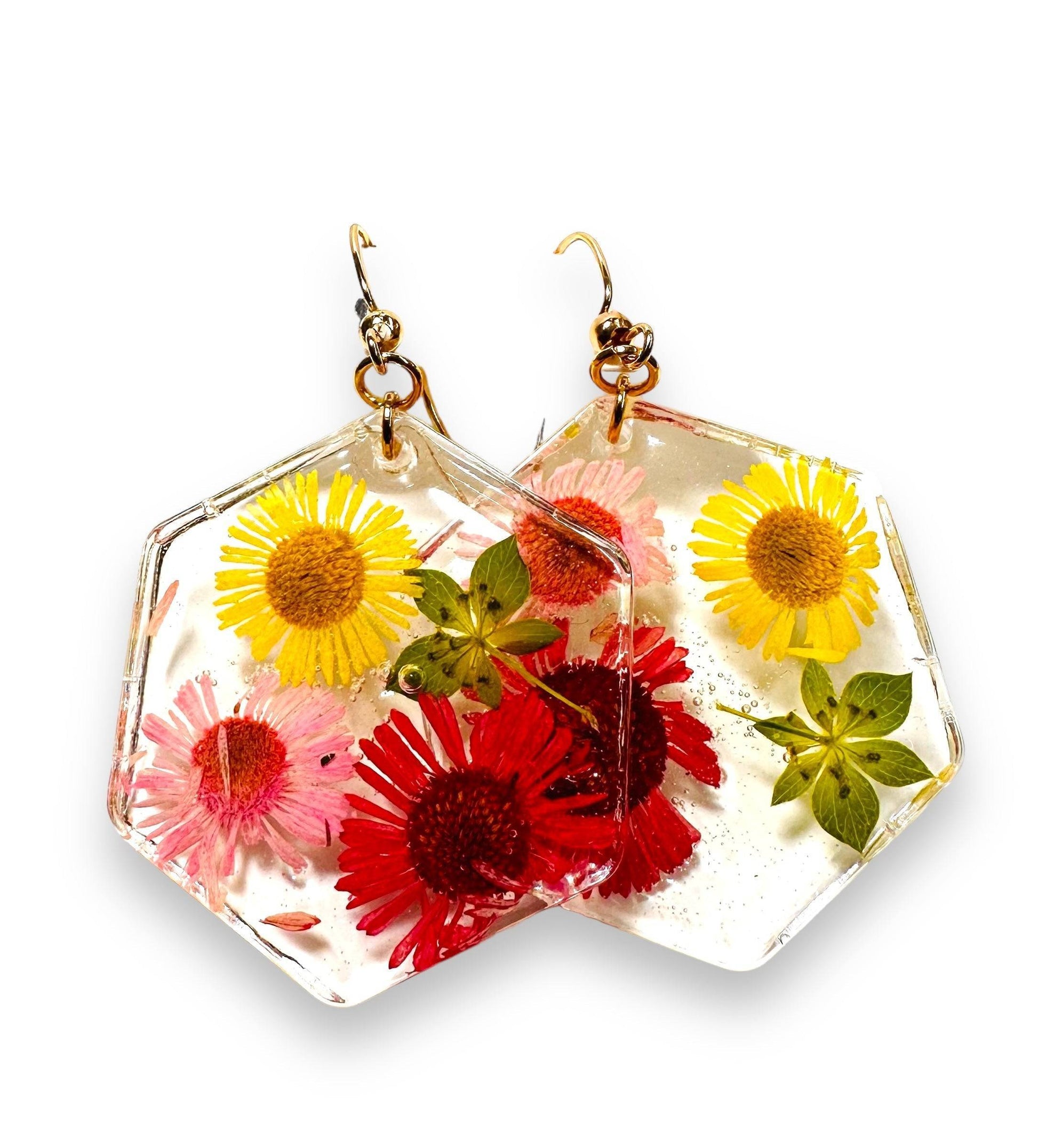 Hexagon resin earrings with red, pink, and yellow flowers and gold hooks. Bold pressed flower earrings with a vibrant floral design.