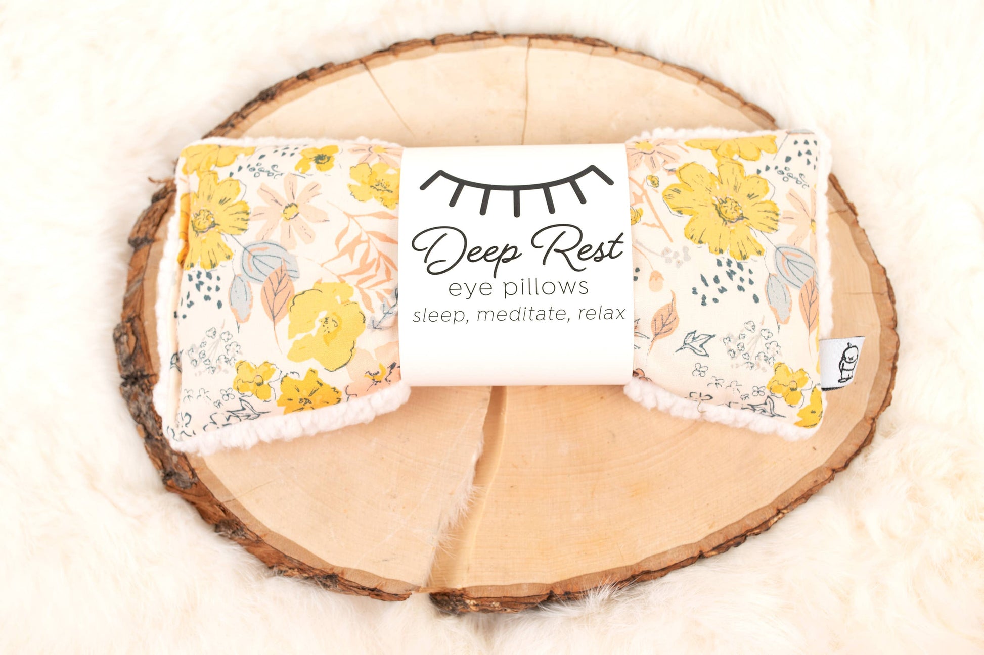 Deep Rest Eye Pillow - Relaxation & Sleep Aid with yellow floral pattern, displayed on rustic wood and fur for cozy home decor appeal.