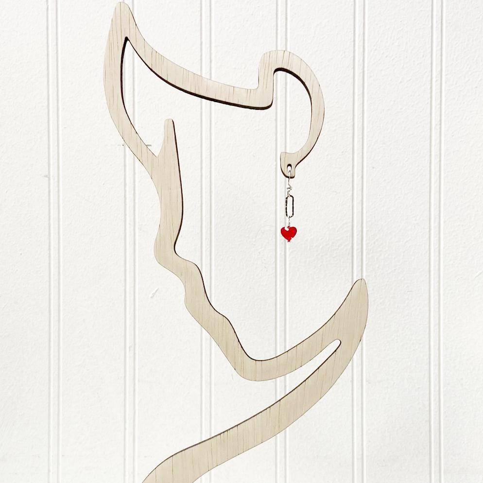 Red Heart Earrings - Standout Jewelry with Red Crystals displayed on a minimalist face-shaped earring stand, highlighting the vibrant red heart charm.