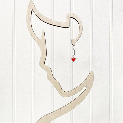 Red Heart Earrings - Standout Jewelry with Red Crystals displayed on a minimalist face-shaped earring stand, highlighting the vibrant red heart charm.