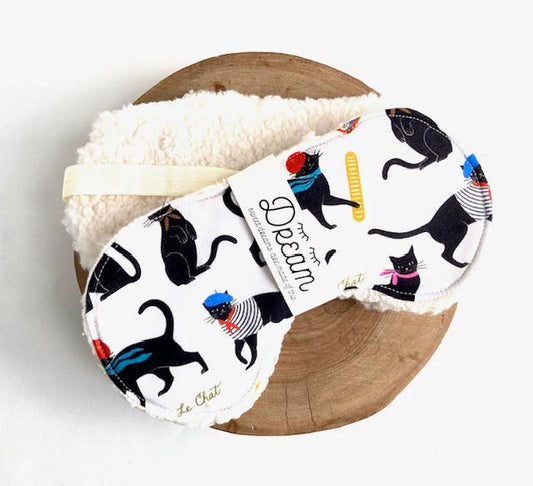 Le Chat Cotton Sleep Mask with playful black cat print on 100% cotton front and soft Sherpa back, ideal for relaxation and sleep aid.