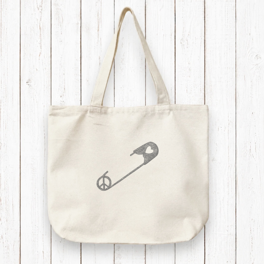 Uni-T organic cotton canvas tote bag in natural beige featuring a red safety pin design with a peace sign and heart.