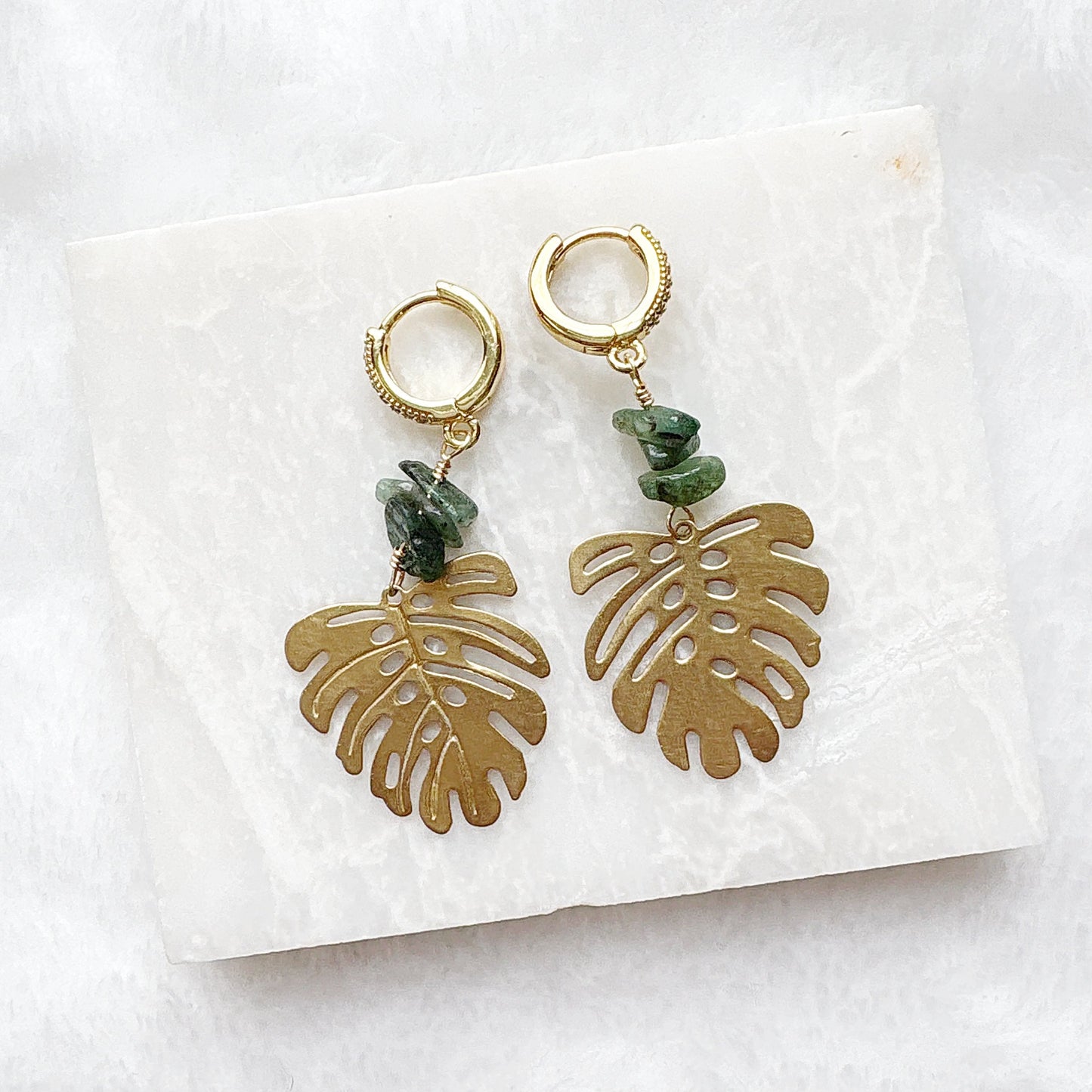Gold Monstera leaf earrings with turquoise stones