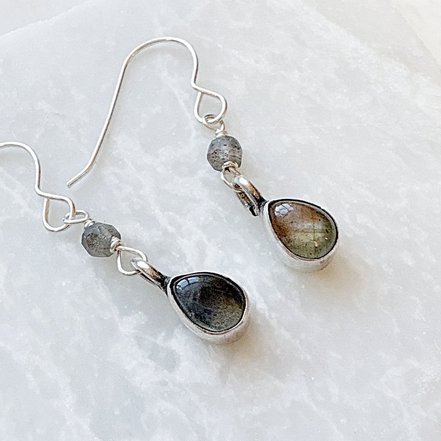 Close-up of Labradorite drop earrings with silver hooks and gemstones