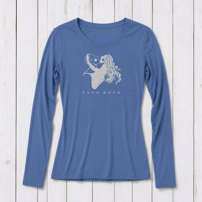 Long sleeve women's graphic t-shirt in blue with a romantic heart and girl illustration, featuring the words love more, on a white wooden background