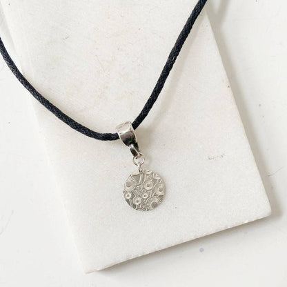 Silver Dandelion Medallion Necklace by Uni-T on black cotton cord, featuring engraved dandelion design in sterling silver for elegant styling.