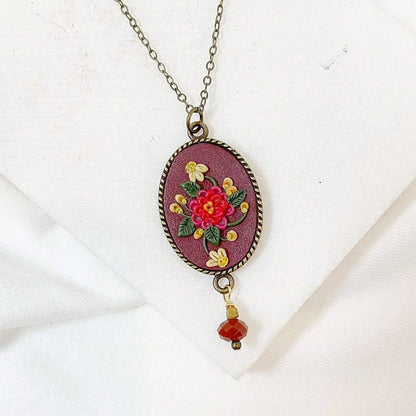 Uni-T Polymer Clay Floral Necklace with red and yellow hand-sculpted flowers on maroon pendant, finished with a red gemstone drop.