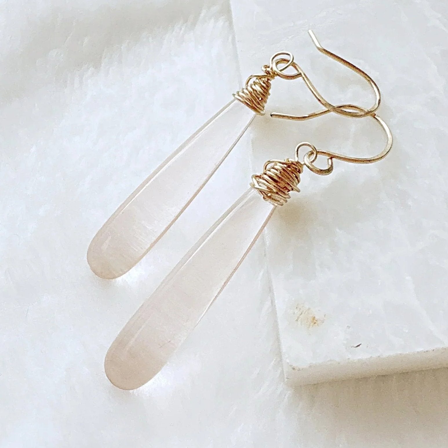 Close-up of handcrafted pink gemstone teardrop earrings