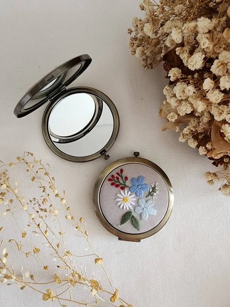 Sophia Collection compact mirror with multicolor floral embroidery on grey linen, stylish and functional beauty accessory gift.