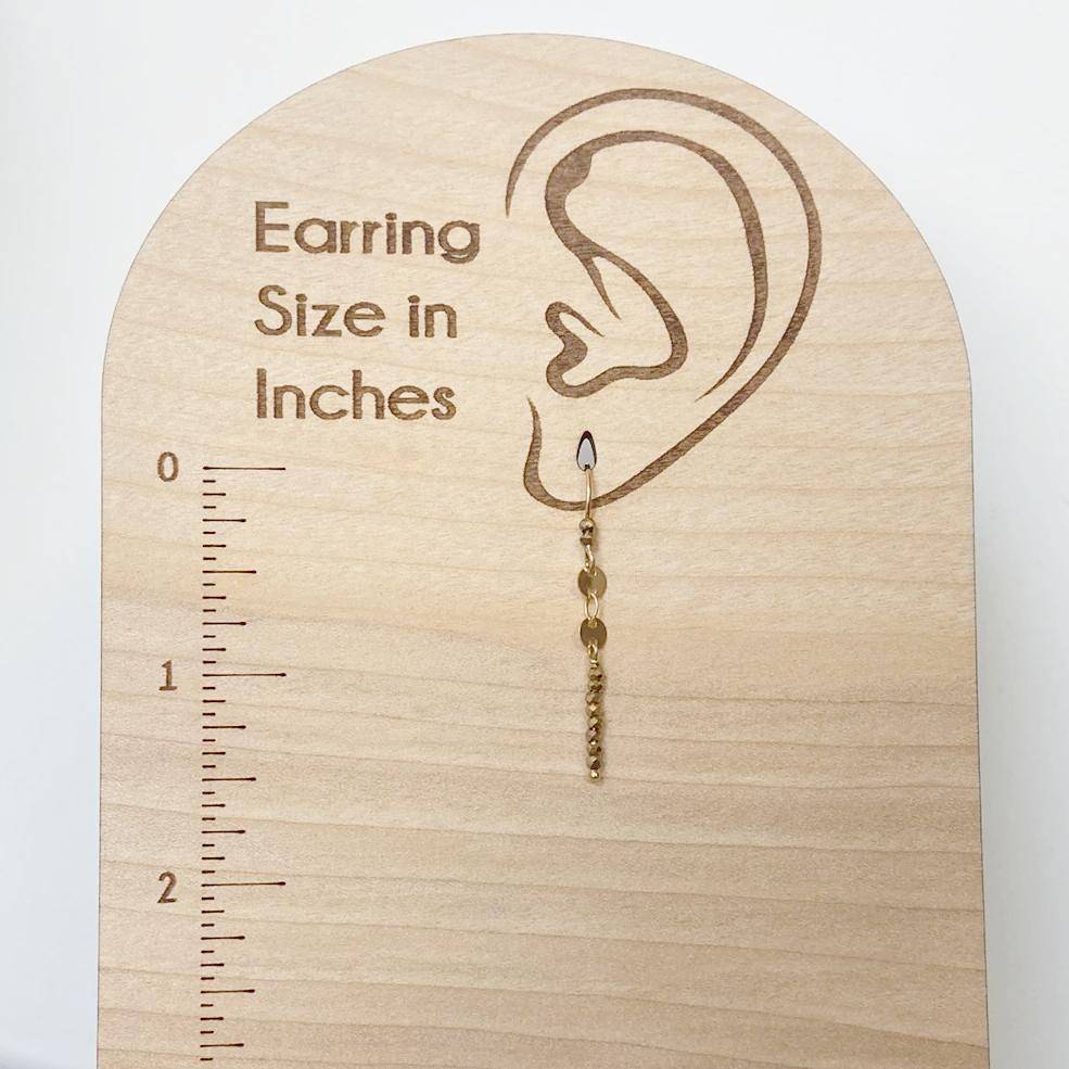 Dainty Gemstone Earrings - Gemstone Silver Earrings shown on wooden size chart. Features gold hooks and hematite gemstone bar for stylish measurement reference.