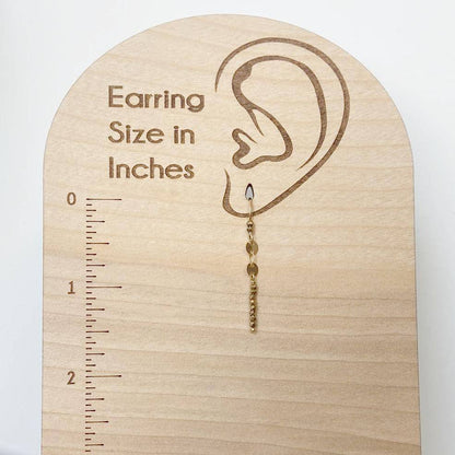 Dainty Gemstone Earrings - Gemstone Silver Earrings shown on wooden size chart. Features gold hooks and hematite gemstone bar for stylish measurement reference.