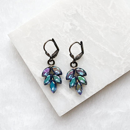 Close-up of vintage brass crystal dangle earrings with colorful iridescent beads
