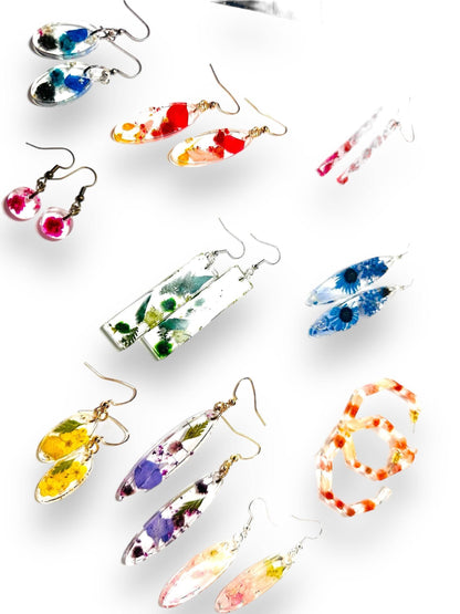 Assorted resin earrings with real flowers in various colors and shapes. Handmade pressed flower earrings with gold and silver hooks.
