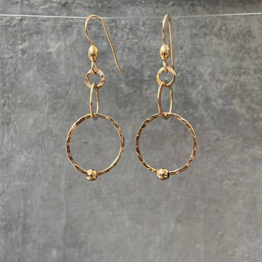 HoopLink Earrings in gold with hammered texture and soldered links, hanging against a gray background. Durable design for everyday wear.