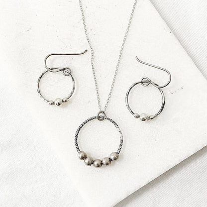 Circle Fidget Earrings & Necklace - Circle Fidget Jewelry Set featuring hammered silver circles with bead accents on a white background.