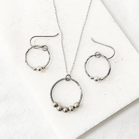 Circle Fidget Earrings & Necklace - Circle Fidget Jewelry Set featuring hammered silver circles with bead accents on a white background.