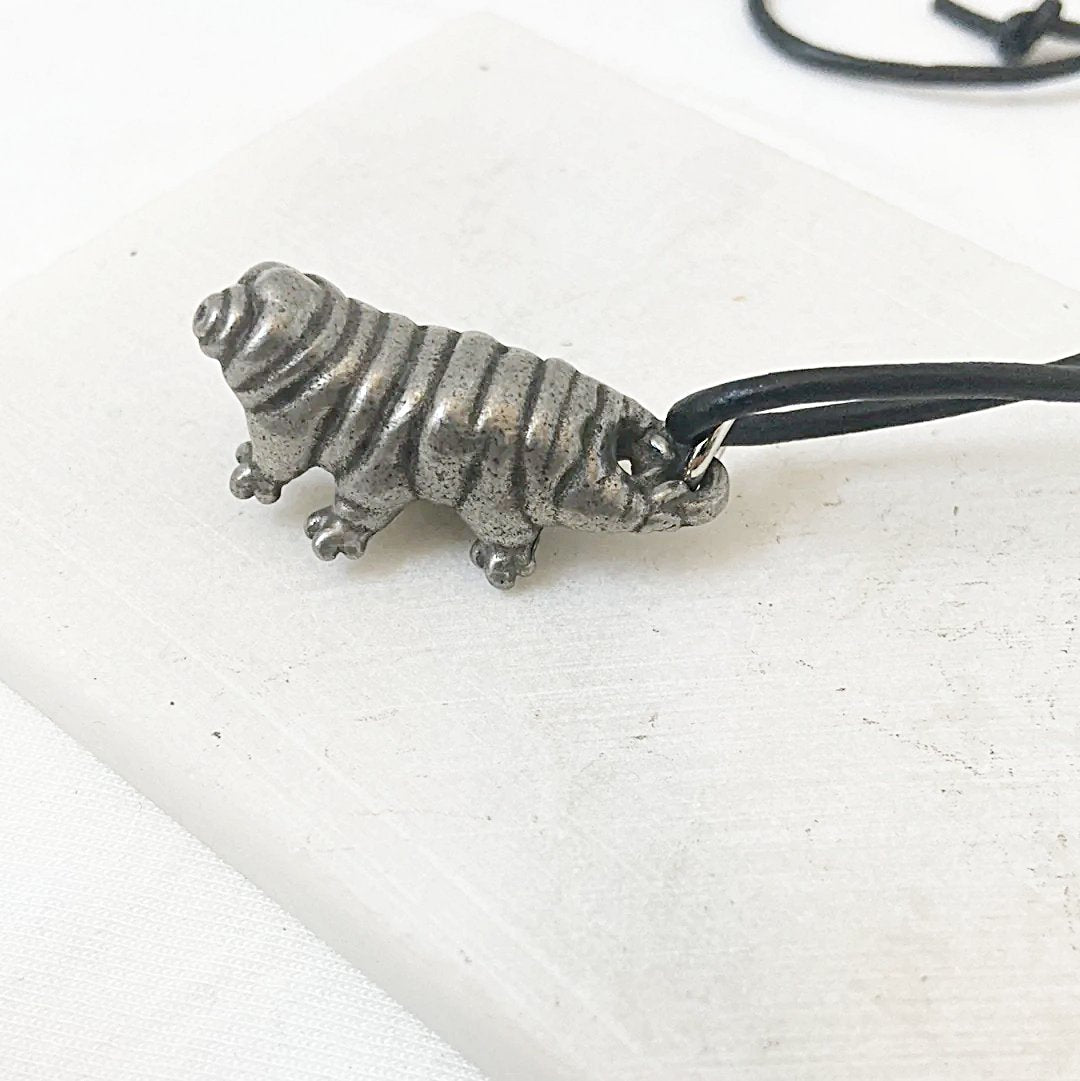 Side view of Tardigrade Necklace with realistic silver water bear charm. A creative piece of tardigrade jewelry on a black cord.