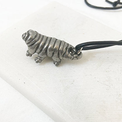 Side view of Tardigrade Necklace with realistic silver water bear charm. A creative piece of tardigrade jewelry on a black cord.