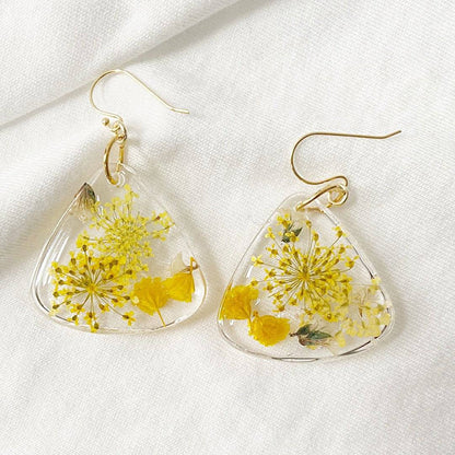 Triangle resin earrings with yellow flowers on white fabric. Natural floral design from Pressed Flower Earrings - Real Flowers.