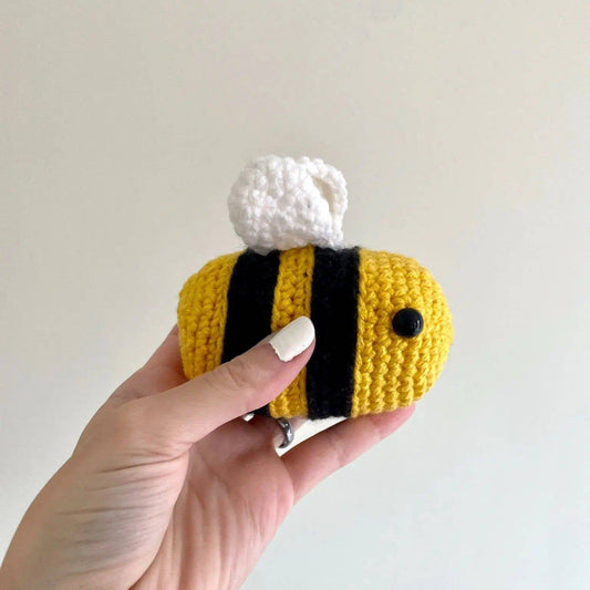 Belinda Bee Stress Ball - Relieve Stress | Compact & Handmade. A hand holding a small, plush crochet bee stress ball with white wings and black stripes.