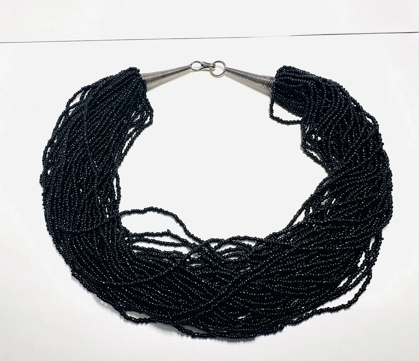 Vintage Black Beaded Necklace with multiple glass bead strands and metal cone ends, perfect for elegant and bold fashion styling.