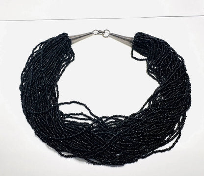 Vintage Black Beaded Necklace with multiple glass bead strands and metal cone ends, perfect for elegant and bold fashion styling.