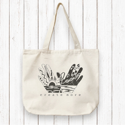 Create More with Organic Canvas Artist Tote Bag featuring illustrated hands and creative elements. Eco-friendly and ideal for artists and creators.