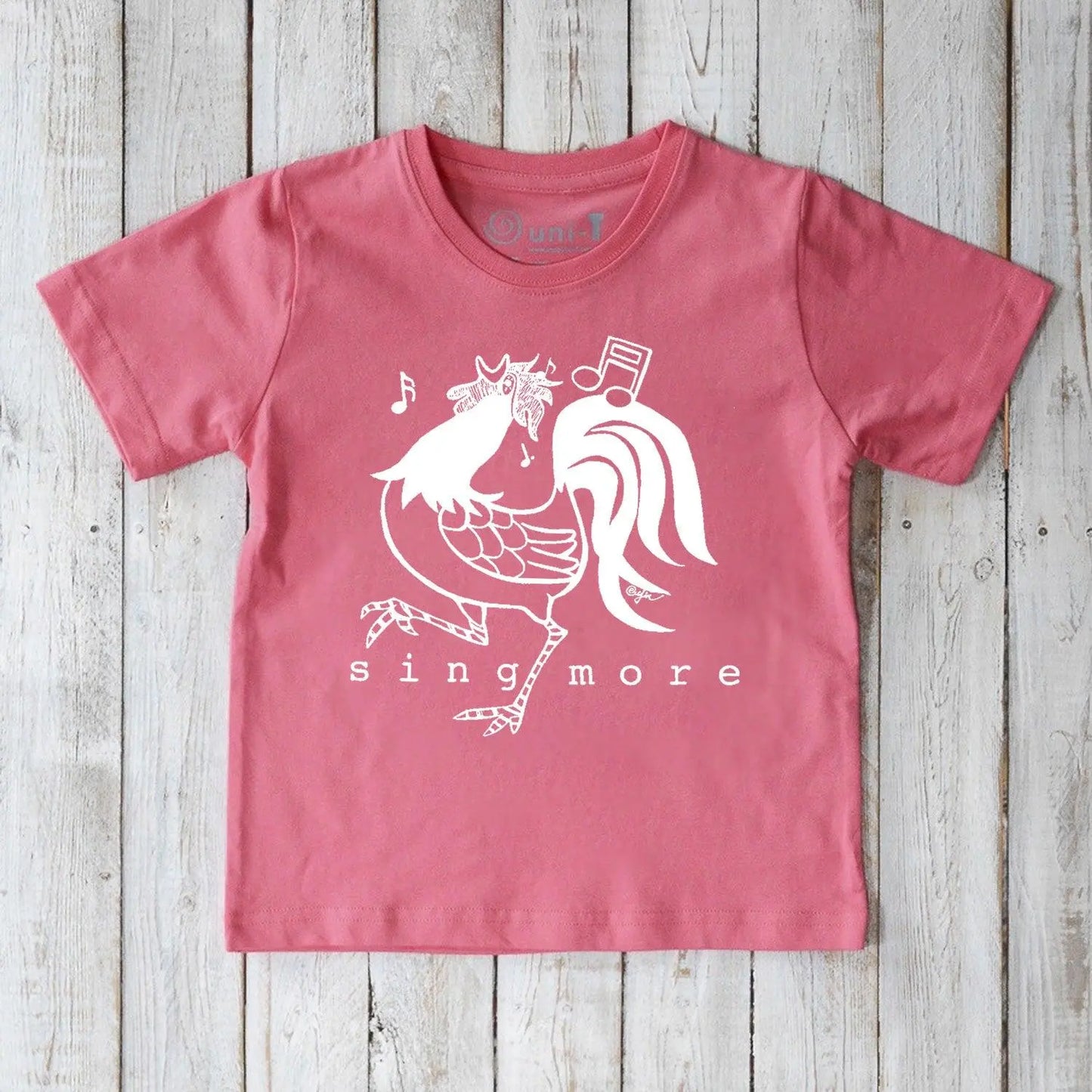 Kids' Rooster Organic Cotton T-Shirt in pink with playful 'Sing More' graphic, sustainable farm-inspired tee for children.