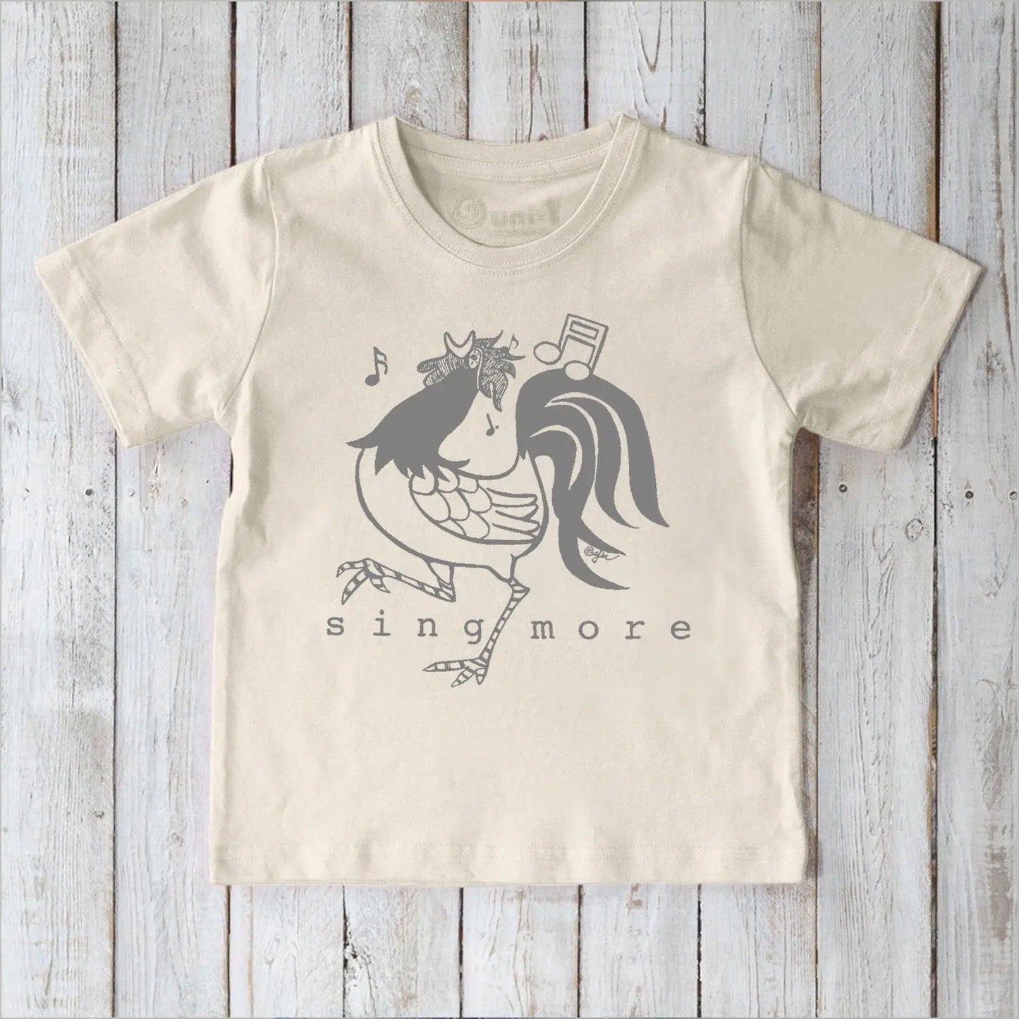 Eco-friendly kids' rooster graphic tee in cream, organic cotton shirt with 'Sing More' text, perfect for sensitive skin.