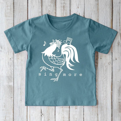 Blue kids' rooster t-shirt made from organic cotton, featuring a cheerful 'Sing More' print, ideal for eco-conscious families.