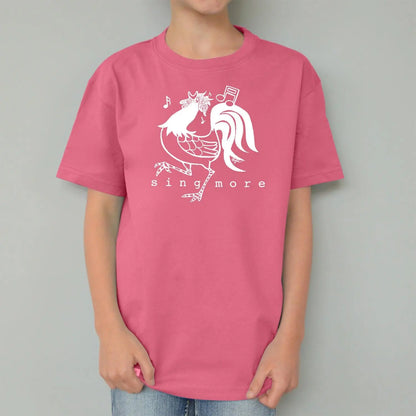 Pink kids' organic cotton t-shirt with white rooster and 'Sing More' design, sustainable and fun farm-themed top for children.
